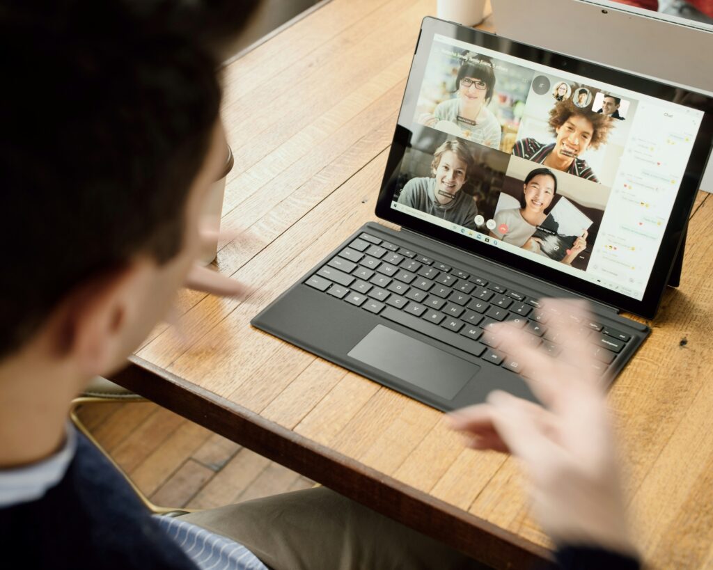 A man talking to a group of people on his laptop.