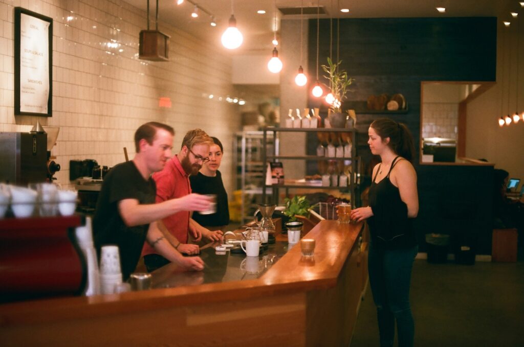 A group of people behind a counter preparing drinks.